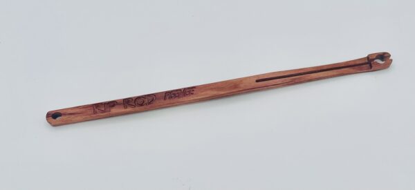 A wooden tool with a narrow, elongated shape, a slot running along one end, a small hole at the opposite end, and "KP ROD" engraved on the side. The object is placed on a plain white background.