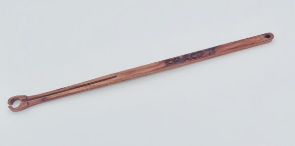 A handcrafted wooden stick with a notched end, possibly a tool or utensil, engraved with "RIP RCD '17" near the handle, displayed on a plain white background.