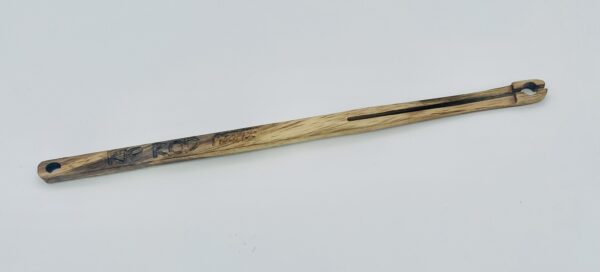A wooden tool with a slot running along most of its length and a small hooked end, engraved with text that includes "Inc. Prod." and "Tecoma." The tool has a hole at one end.