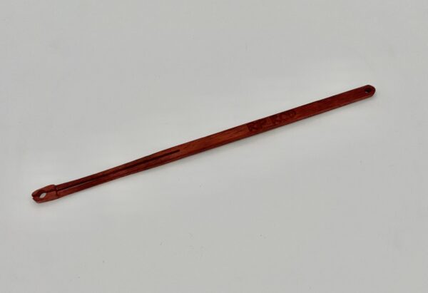 A slender, reddish-brown wooden tool with a pointed tip and a small loop at one end, photographed on a plain white background.