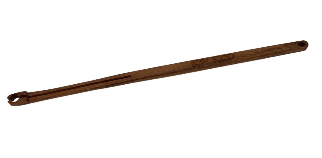 A Tigerwood tool with a long narrow handle, slotted forked end, engraved text, and a hanging hole at the other end.